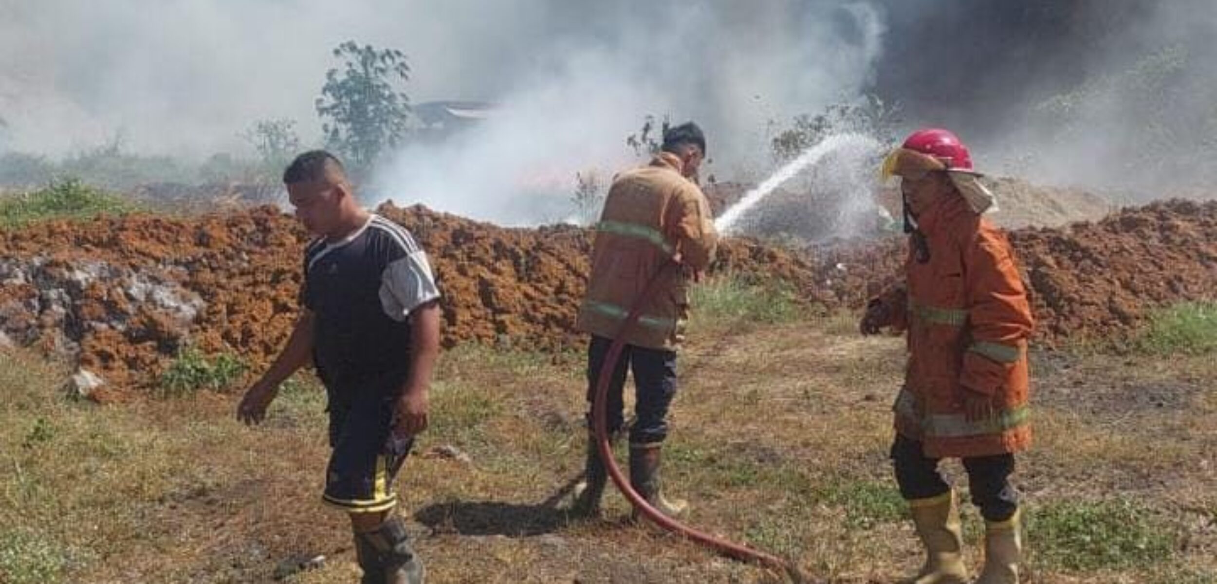 Petugas Damkar saat melakukan pembasahan di lahan kosong yang digunakan sebagai tempat penimbunan sampah pabrik di Dusun Buluresik, Desa Manduro Manggung Gajah, Kecamatan Ngoro, Kabupaten Mojokerto, Sabtu (2/8/2025) siang (Redaksi / Kabarterdepan.com)