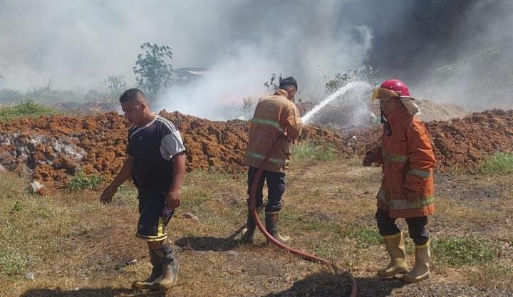 Petugas Damkar saat melakukan pembasahan di lahan kosong yang digunakan sebagai tempat penimbunan sampah pabrik di Dusun Buluresik, Desa Manduro Manggung Gajah, Kecamatan Ngoro, Kabupaten Mojokerto, Sabtu (2/8/2025) siang (Redaksi / Kabarterdepan.com)