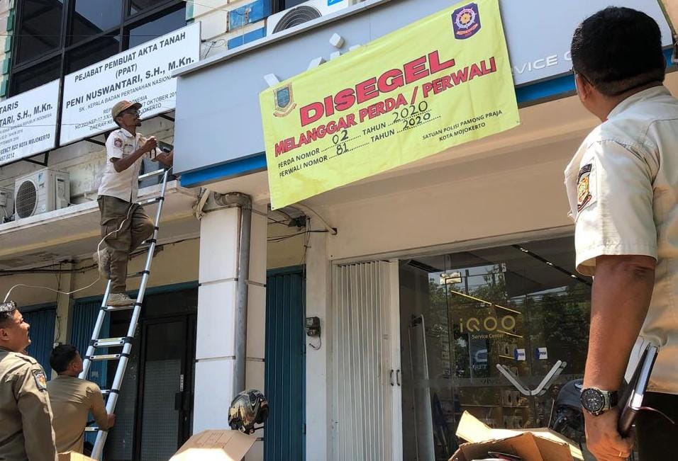 Satpol PP Kota Mojokerto menyegel papan nama service center Vivo, Kamis 25/9/2025 (Redaksi / Kabarterdepan.com)