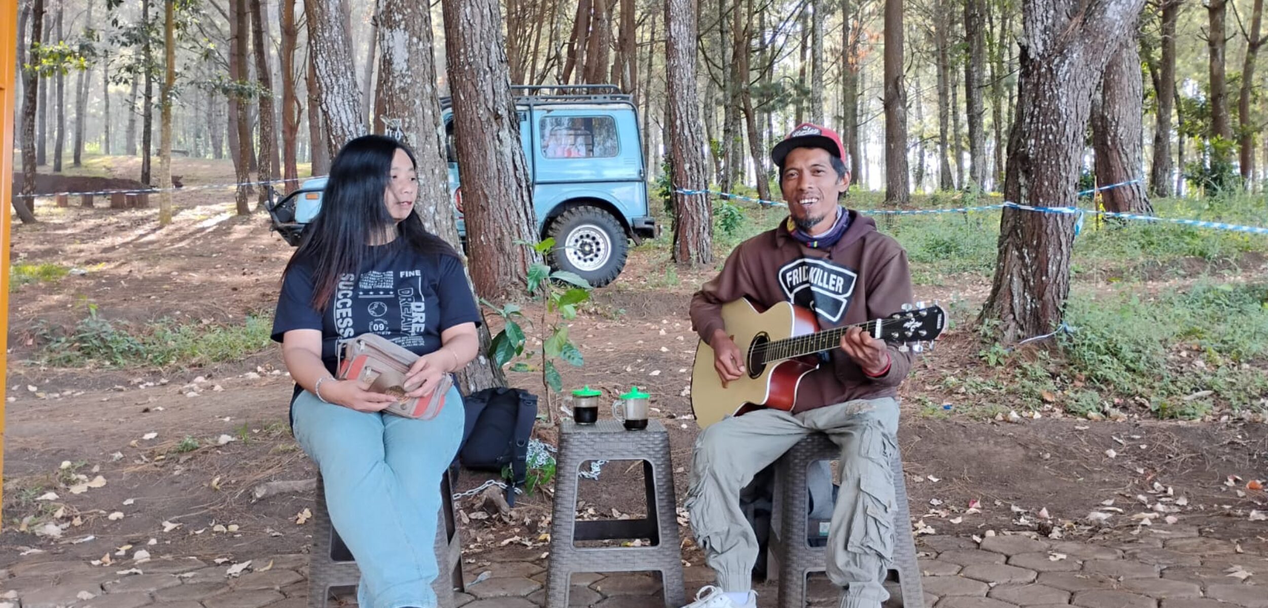 Pengamen penyandang disabilitas, Eko Pramono saat tengah mengamen di Payung Pinus, Jalibar bersama salah seorang wisatawan yang request lagu. (Yan / Kabarterdepan.com)