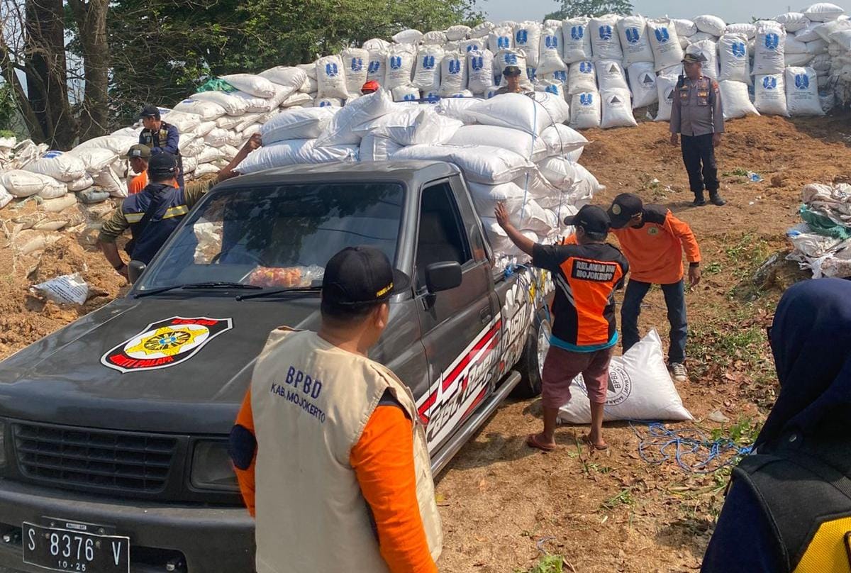 Potret sejumlah relawan saat memasang tumpukan sekam ke jalur penyelamat sebagai benteng penyelamat. (Redaksi / Kabarterdepan.com)
