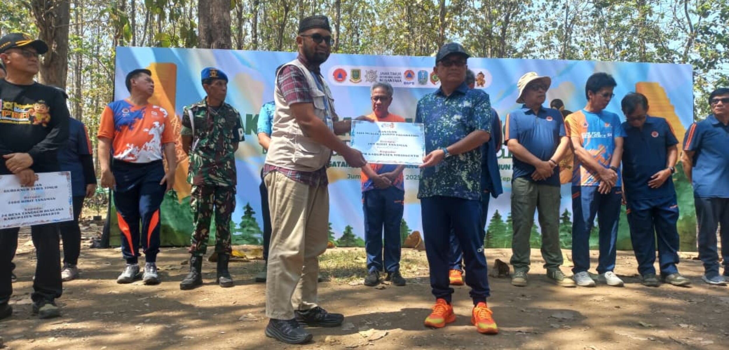 Sestama BNPB, Dr. Rustian mewakili Kepala BNPB menyerahkan secara simbolis bibit pohon dalam rangkaian Puncak Peringatan Bulan PRB 2025 (foto: AMCF)
