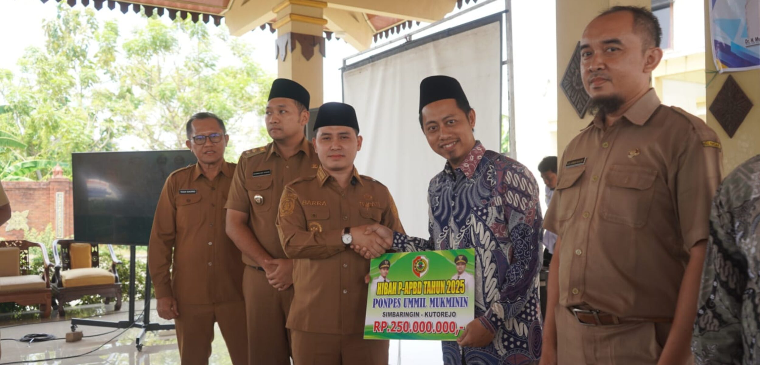 Bupati Mojokerto Muhammad Albarra menyerahkan secara simbolis hibah P-APBD 2025. (Kominfo Kab Mojokerto)