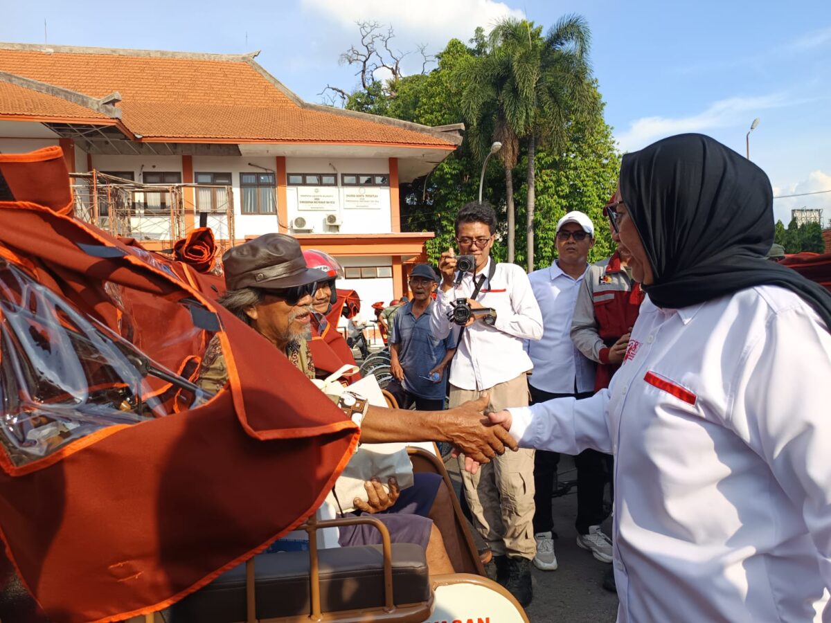 PENYERAHAN BECAK LISTRIK: Wakil Ketua Umum Yayasan GSN Nanik S Dayang bersalaman dengan salah satu tukang becak penerima becak listrik bantuan Presiden Prabowo. (Ezra/kabarterdepan.com) 