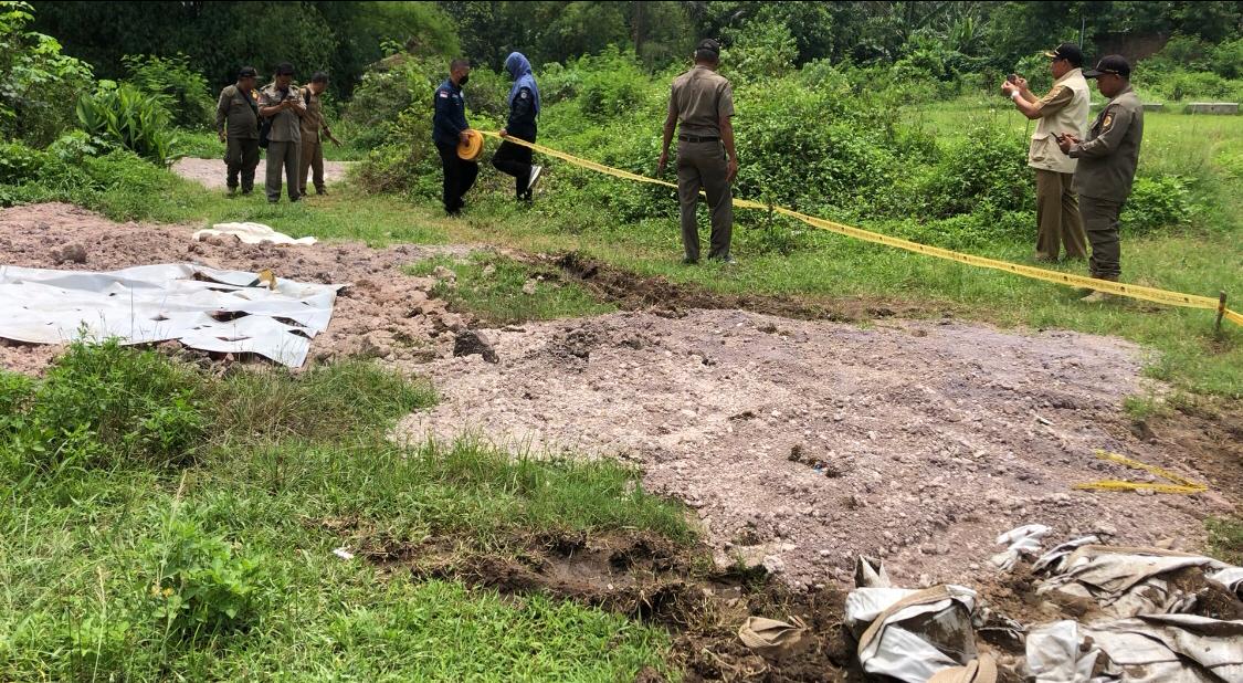 Petugas dari Pengawas DLH Kabupaten Mojokerto saat memasang garis larangan. (Redaksi Kabar Terdepan)
