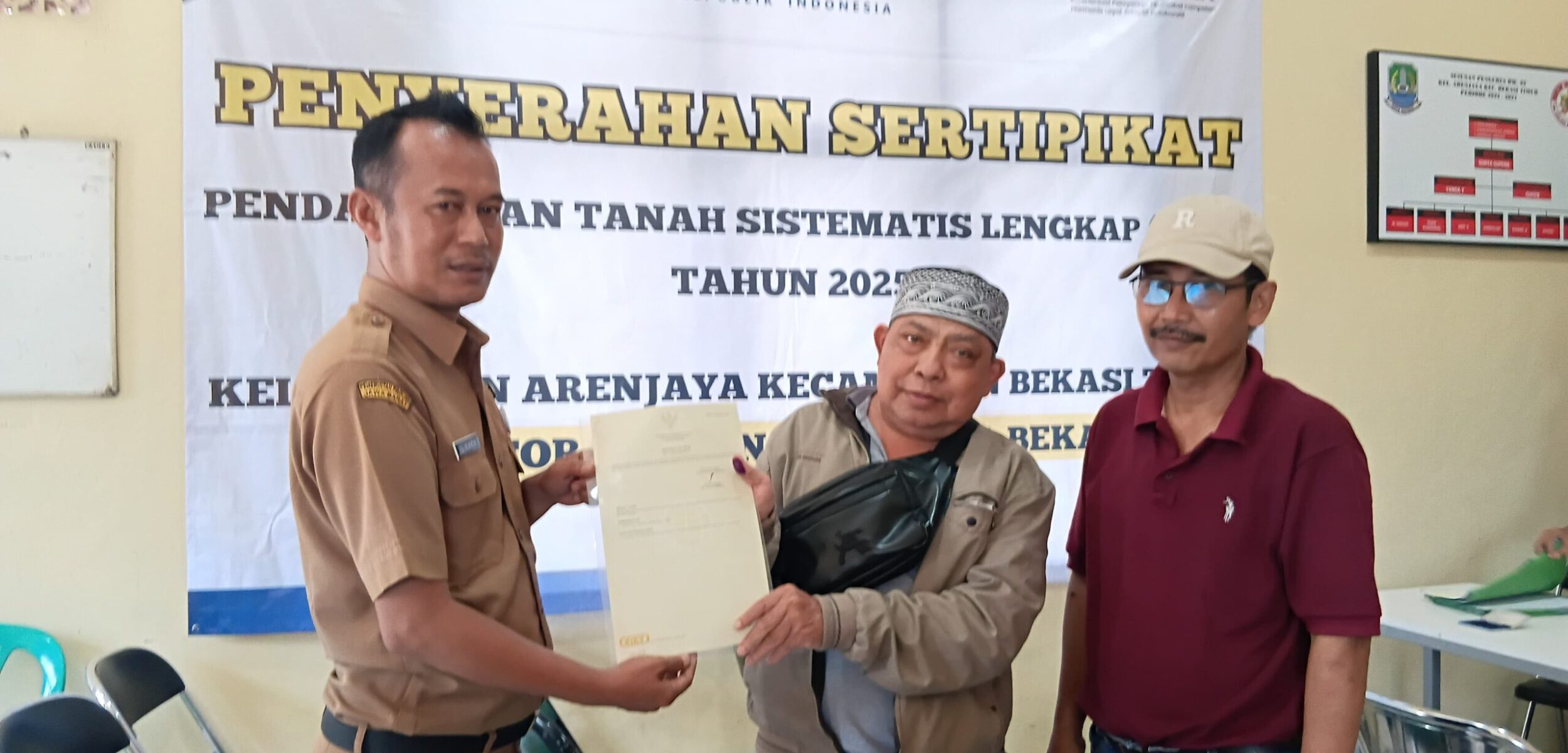 Kasipemtibum Kelurahan Arenjaya menyerahkan sertifikat PTSL ke warga Arenjaya. (Yanso/kabarterdepan.com) 
