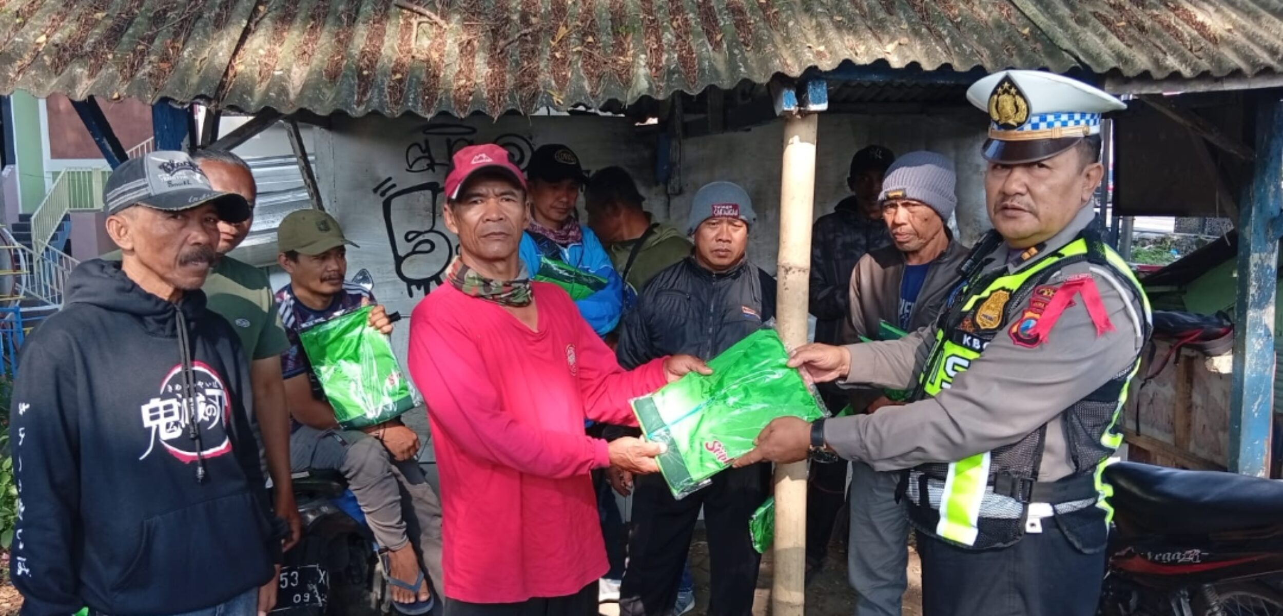 KBO Satlantas Polres Batu, Iptu Rofiq didampingi Ps. Kanit Kamsel Sat Lantas Polres Batu, Aiptu Nurhadi, saat membagikan Rompi Supeltas. (Yan)