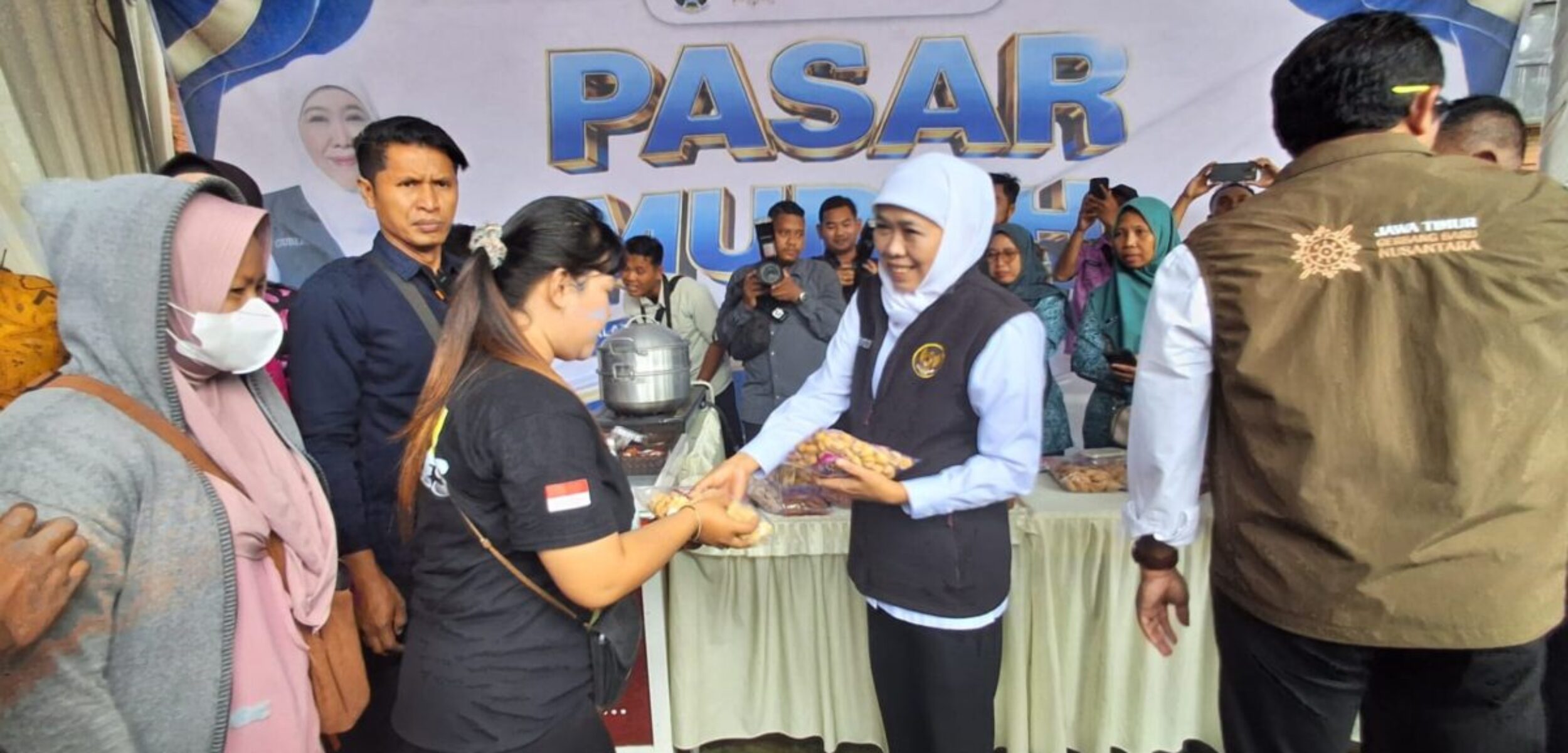 Gubernur Jatim, Khofifah Indar Parawansa saat memberikan beberapa minuman ke warga. Sumber: (Segaf/Kabarterdepan.com)